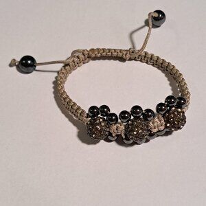 tan beige rope bracelet with large gun metal color round beads and shiny stones